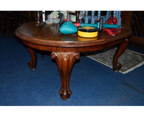 A HEAVY VICTORIAN WALNUT OVAL TOPPED WIND OUT TABLE, with additional leaf on scrolled legs and large white ceramic casters, a