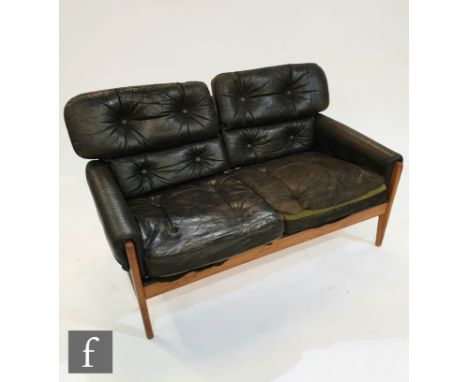 Attributed to Parker Knoll - A black button down leather and teak framed two seat sofa, A/F.PROVENANCE : FROM THE COLLECTION 