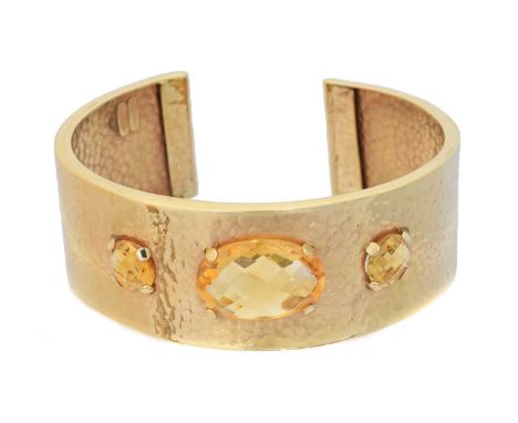 A 9ct gold citrine bangle, A 9ct gold citrine bangle, the circular and oval briolette cut citrine line inset to the planished