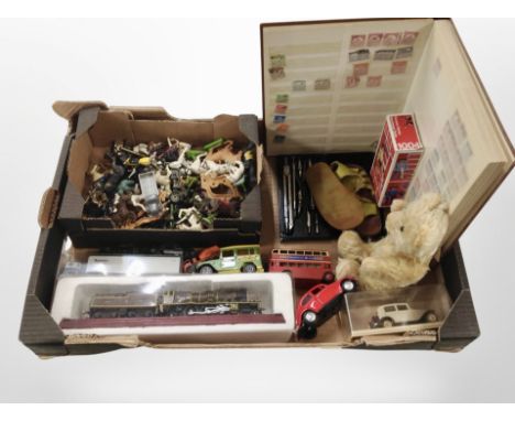 A box containing diecast cars and model train, farm animals, a vintage teddy bear, a stamp album, etc.