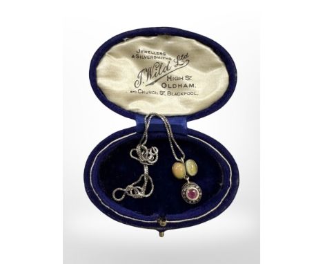 An old silver pendant and chain set with opal, ruby and diamond.