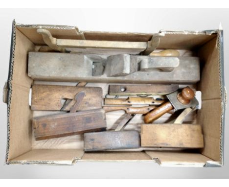 A box containing antique woodworking planes, spirit level, etc.