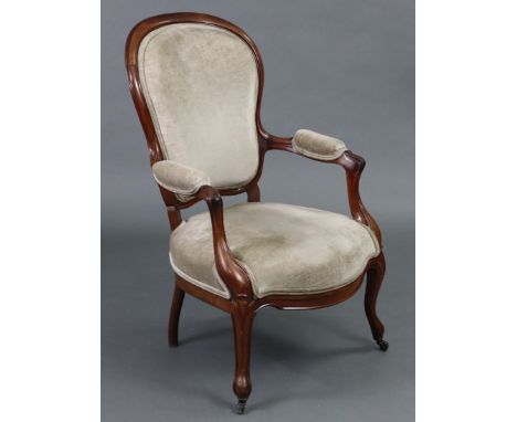 A Victorian mahogany frame spoon-back elbow chair, with padded seat, back &amp; arms upholstered light grey velour, on carved