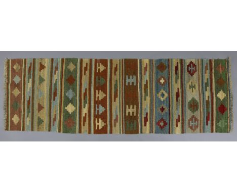 A Kelim small runner of fawn, blue, &amp; green ground with all-over repeating striped geometric design; 7’4” x 2’4”.