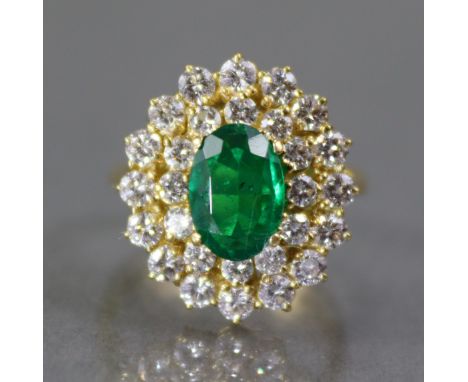 AN EMERALD &amp; DIAMOND RING, the oval-cut emerald weighing approx. 0.8 carat, set within a double border of twenty eight sm