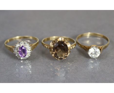 A 9ct. gold ring set oval amethyst within a border of small diamonds, size: O, (1.6gm); another set smoky quartz, size: N, (2