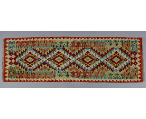 A Choli Kilim runner, with a multicoloured geometric pattern of four lozenges within a wide border, 25” wide x 81½” long.