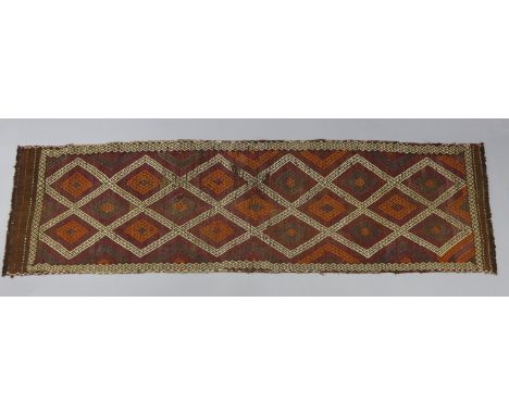 A Suzni Kilim runner of ochre ground, with repeating lozenge designs to the centre within a narrow border in magenta, mauve, 