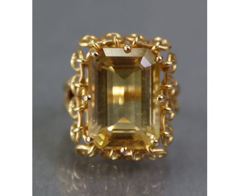 A CITRINE RING, the large rectangular stone weighing approx. 9 carats, set to a cage-work mount &amp; un-marked yellow metal 