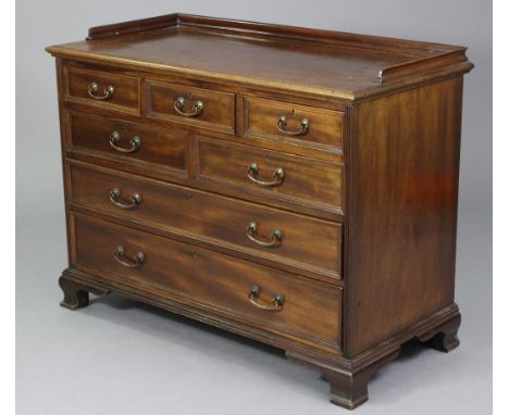 A Georgian style mahogany low tray-top chest, fitted an arrangement of seven drawers with brass swan-neck handles, &amp; on o