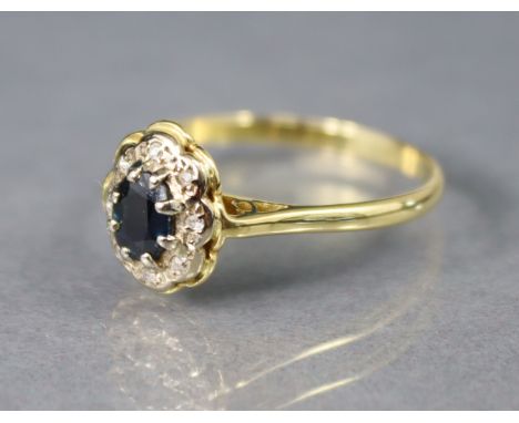 A sapphire &amp; diamond ring, the oval sapphire set within a border of tiny diamonds, the shank marked “18ct.”; size V; (3.9