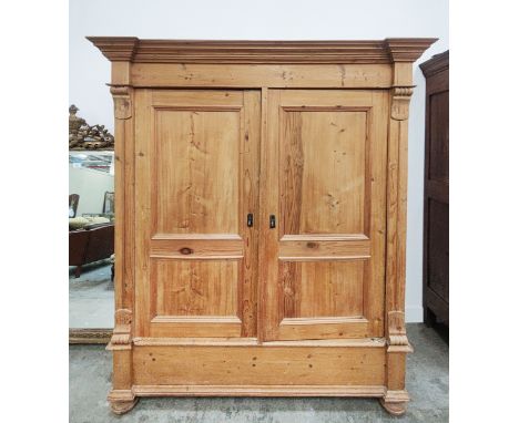 PINE ARMOIRE, 19th century German, with a pair of panelled doors enclosing a hanging rail and shelf, 195cm H x 69cm D x 162cm