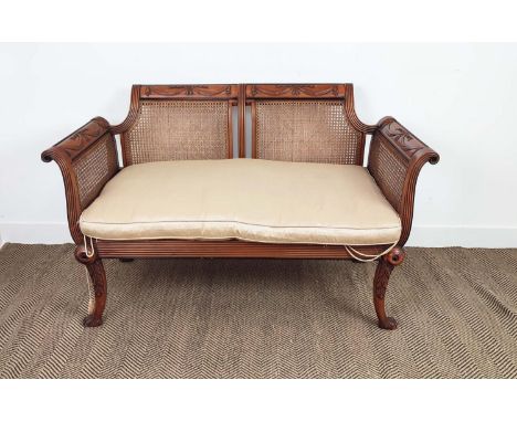 BERGERE SOFA, Regency style beechwood, ebonised and caned with squab cushion, 86cm H x 136cm W x 68cm D. 