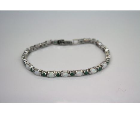 A silver opal and emerald line bracelet