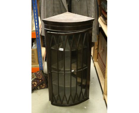 19th century Mahogany Bow Fronted Hanging Corner Cabinet with Single Astragel Glazed Door opening to reveal three shaped shel