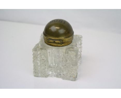 A antique cut glass inkwell with brass hinged lid dated 1900.