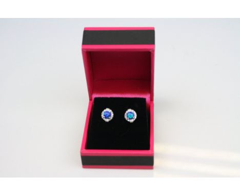 A pair of silver stud earrings set with opal and CZs