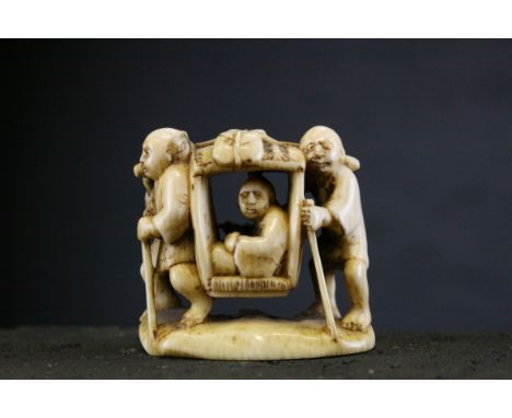 A 19th century ivory netsuke of a man being carried in a sedan chair, signed, each attendant carrying a stick in their left h