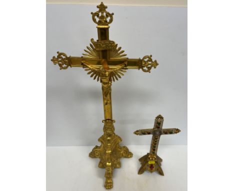 A 19th Century gilt brass altar crucifix raised on three heavy lion's paw feet 61.5 cm high together with another smaller alt