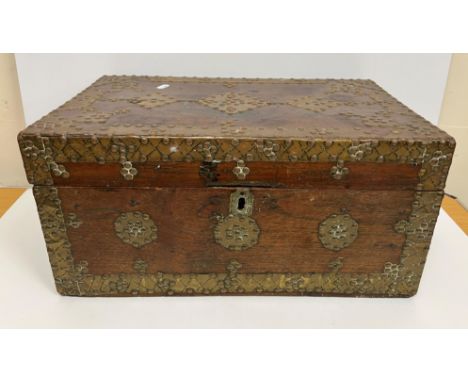 An Indian teak brass bound and studded trunk of rectangular form, the top opening to reveal a sectional interior with well, 5