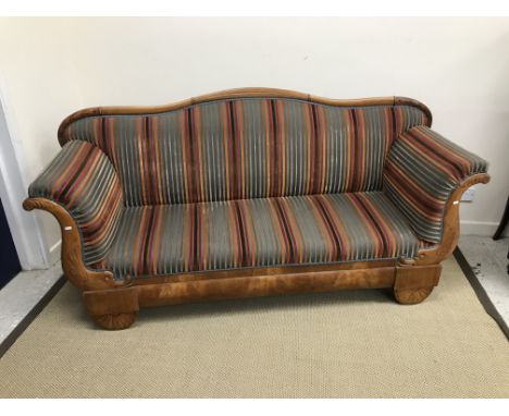 A 19th Century Biedermeier cherry wood framed sofa, the reeded and foliate carved serpentine top rail above upholstered back,