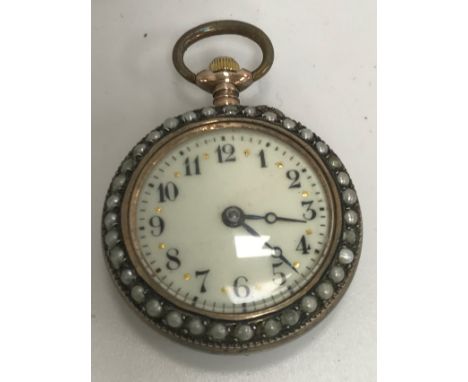 A Swiss silver enamel and seed pearl decorated watch, the back depicting a scene of a courting couple, the enamel dial set wi
