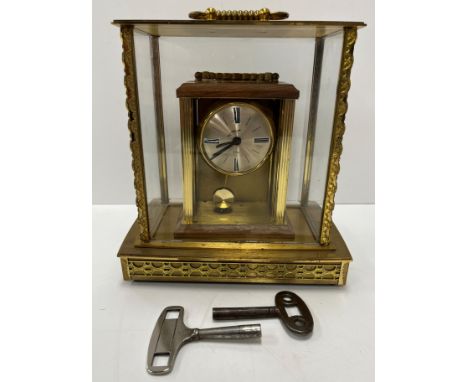 A Continental brass cased mantle clock, an ebonised architectural form mantle clock and a mid 20th Century brass four glass m