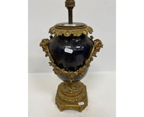 A gilt brass and bleu royale pottery table lamp in the Classical manner with satyric or bacchanalian mask side handles and fl