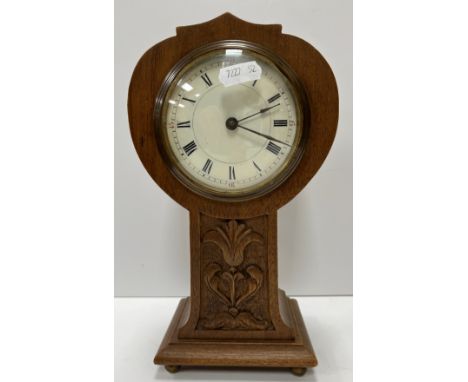 A circa 1900 walnut cased balloon style mantle clock with carved decoration to the column, the French movement with circular 