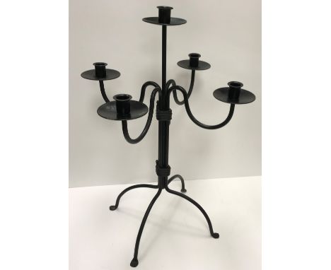 A wrought iron four branch five light candelabra in the 19th Century manner on a plain column to splayed quaduped base and sc