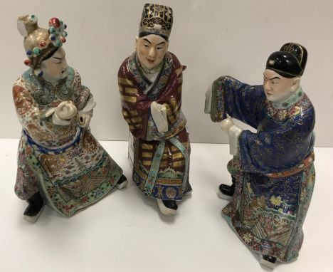 A set of three 19th Century Chinese polychrome decorated figures, one seated, one bearing sword, the other grimacing approx. 