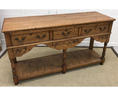 A modern oak dresser in the early 19th Century manner, the plain top above three deep and three slim drawers on turned and ri