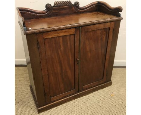 A Victorian mahogany side cabinet, the three quarter galleried top with moulded decoration over two panelled cupboard doors e