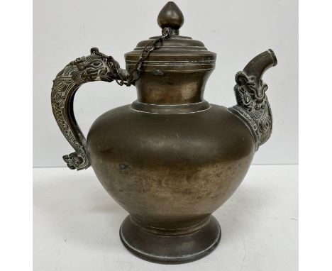 A 19th Century Sino Tibetan bronze teapot with dragon handle and spout in the archaistic manner raised on a circular foot 23.