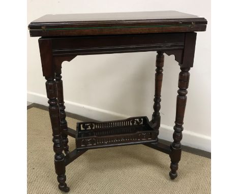 A late Victorian walnut fold over card table, the rectangular top with moulded edge over a moulded frieze on turned and ringe