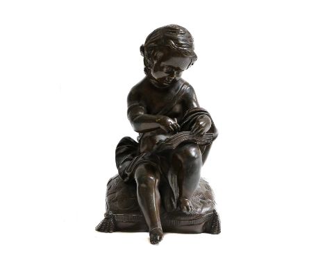 A 19th century bronze of a putto seated on a cushion with journal (possibly formerly a furniture or clock mount), 18cm