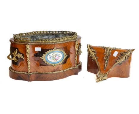 A French tulipwood jardiniere of serpentine form, late 19th century, with gilt metal mounts and set with a Sevres style plaqu