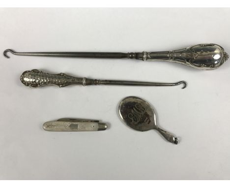 Items of antique silver, including two Edwardian silver handled button hooks, a folding silver fruit knife, and a novelty cha