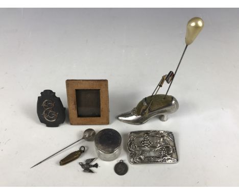 A late Victorian 'New York' souvenir electroplate pin cushion modelled in the form of a shoe, containing four period hat pins