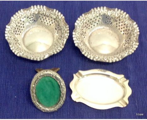 A pair of silver pierced bon bon dishes, a silver ashtray and a miniature silver oval picture frame 12cm diameter