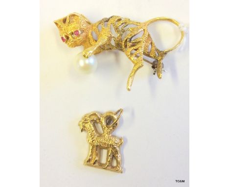 A 9ct gold brooch set with pearl and ruby and a 9ct gold zodiac charm (11 grams)