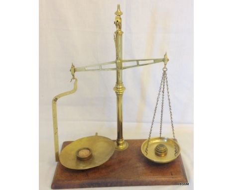 A vintage W and T Avery pair of brass balance scales with round weights on a wooden base 52cm high