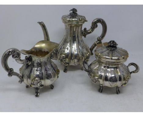 A mid to late 19th century three piece silver tea set, comprising a teapot, twin handled sugar pot and cover, and a milk jug,