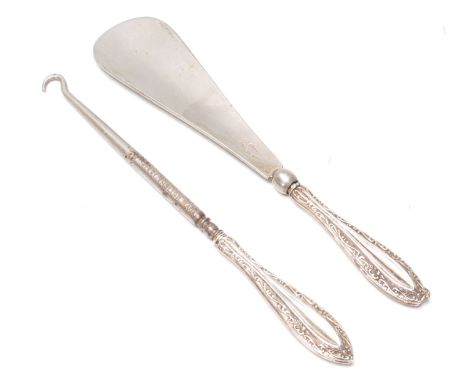A pair of early 20th Century silver handled dressing table items to include a button hook and a shoe horn having having raise