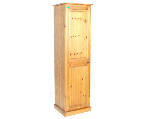 A 20th Century contemporary country pine tall sentry box wardrobe having a single panelled door with a knob handle opening to