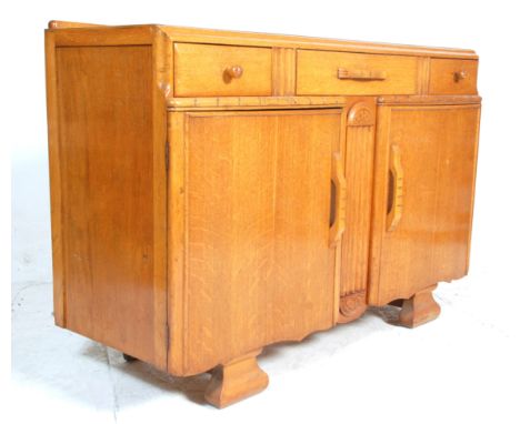A vintage 1930's Art Deco oak dresser - sideboard having three short drawers over two cupboards at the being raised on shaped