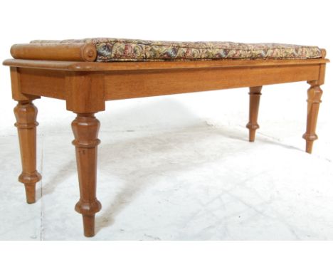 A 19th century Victorian oak window seat / hall bench having a rectangular top with cylindrical carved ends, raised on facete