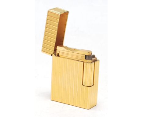 A vintage 20th Century Dupont lighter having a gilt case with engraved striped decoration, with a flip lid to the top and rol