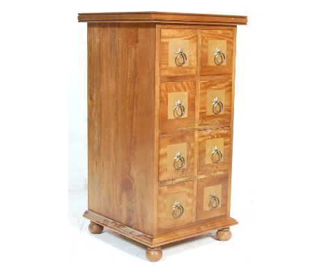 A 20th century antique style colonial revival light hardwood merchants chest having an inlaid top over 8 drawers with ring ha