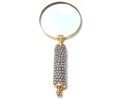 An Edwardian early 20th century magnifying glass having a white metal pebble decoration to the handle and brass edge with a f